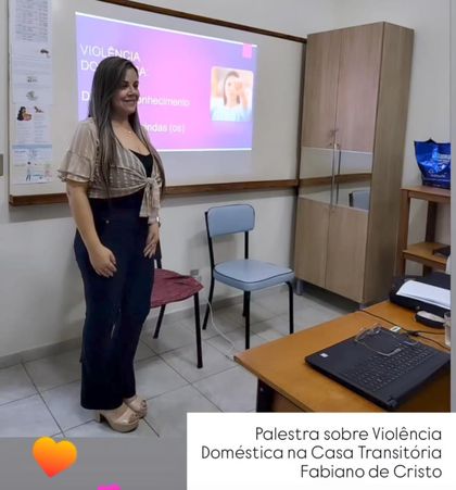 Patrícia Moreira ao lado da projeção durante a palestra sobre violência doméstica.